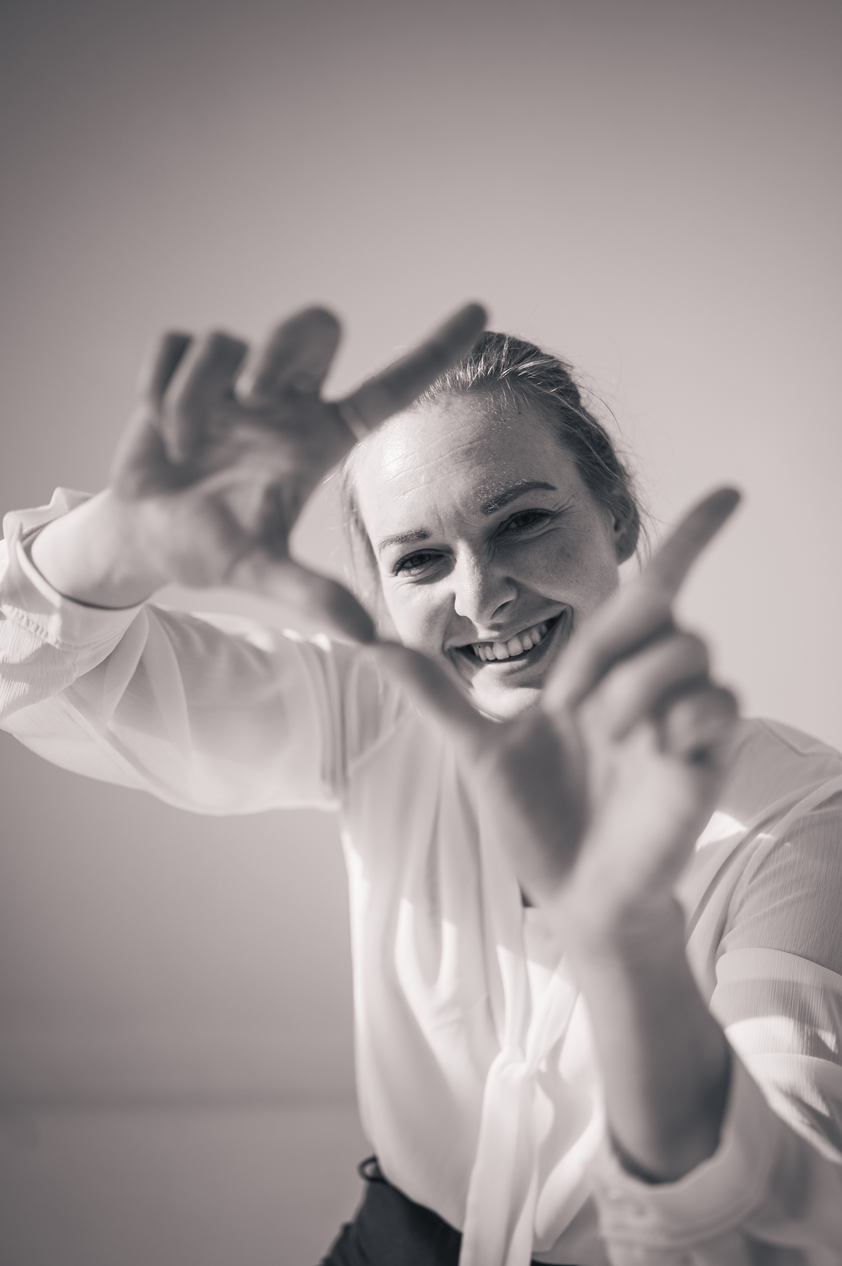 Fotografin symbolisiert mit ihren Händen eine Kamera